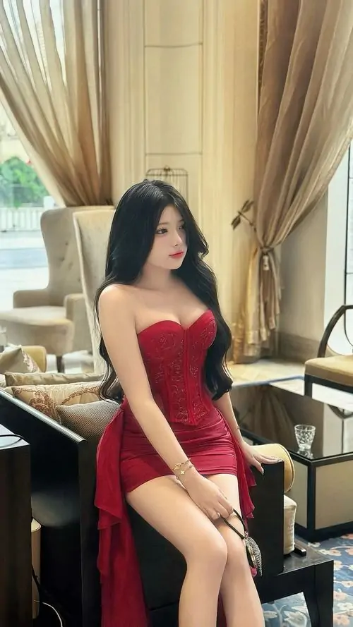 9 Ảnh cô nàng ngồi cạnh rèm cửa với váy đỏ ôm, tóc dài uốn nhẹ và dáng nghiêng làm phần eo thon nổi bật, khung hình trông sang chảnh vừa đủ, rất hợp gu ai thích hình gái xinh mặc váy body kiểu kín đáo mà vẫn sexy