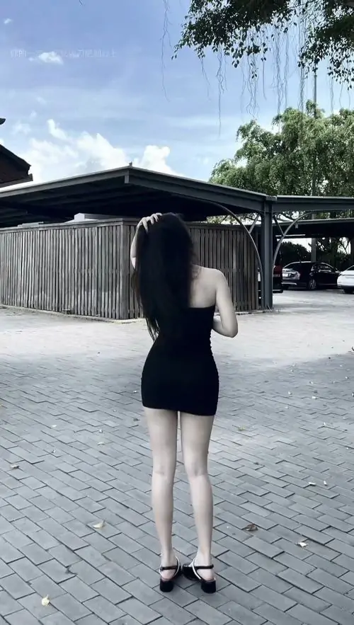 3 Hình gái đẹp chụp từ phía sau với đầm ôm đen ngắn ở khoảng sân lát đá, mái tóc dài phủ lưng và dáng đứng gọn gàng tạo cảm giác trưởng thành, hợp kiểu ảnh nữ xinh trong đầm ôm sát nhìn đơn giản mà vẫn dễ thương