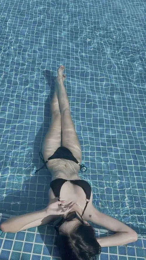 4 Khung hình chụp từ trên cao ghi lại cô gái nổi dưới nước xanh với kiểu dáng đồ bơi tối màu rất đẹp