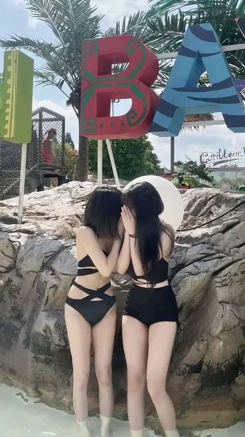 8 Cô gái ngồi co gối trên mỏm đá với monokini cắt xẻ màu tối tóc dài che nửa mặt tạo vẻ bí ẩn