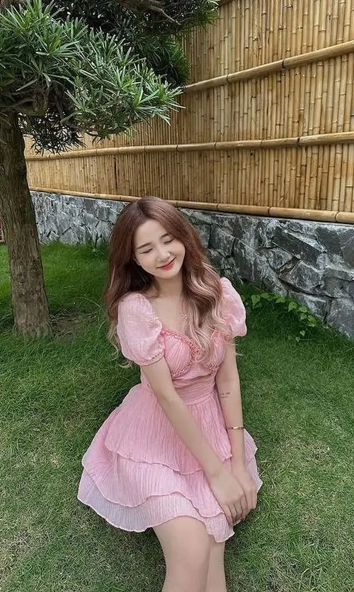 1 Trên thảm cỏ, ảnh gái xinh diện váy pinky xòe nhẹ, dáng đứng nghiêng làm tổng thể ngọt ngào và rất dễ ngắm