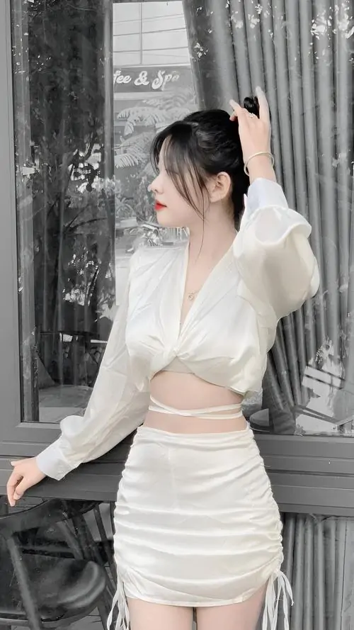 30 Cô nàng mặc váy trắng nhún ôm sát đứng trước rèm sáng, thân hình mảnh và vòng eo gọn khiến khung hình có độ hút cao, đồng thời giữ được vẻ dễ thương nhờ gương mặt nhỏ và sáng