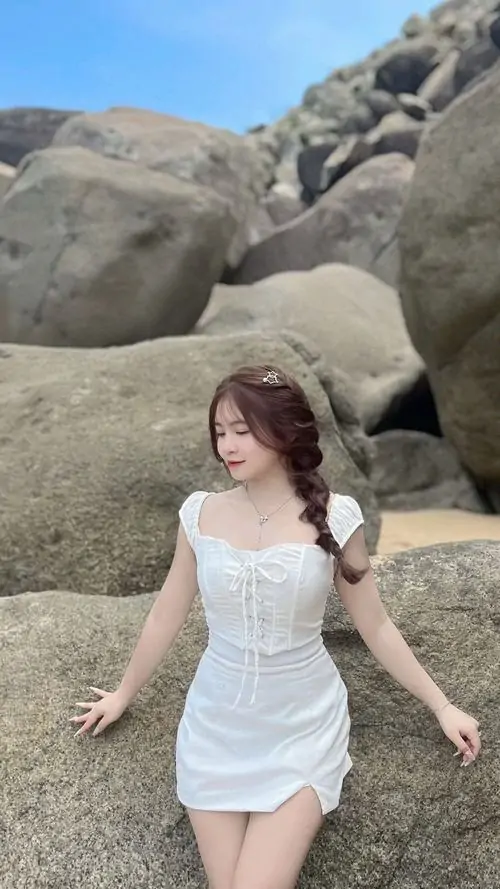 26 Ở bãi đá gần biển, cô nàng diện váy trắng ôm sát với bước đi chậm và mái tóc bay nhẹ, cảnh nền thoáng làm đường cong nổi rõ hơn, bức ảnh vì thế sexy hơn nhưng vẫn giữ vẻ tinh khôi