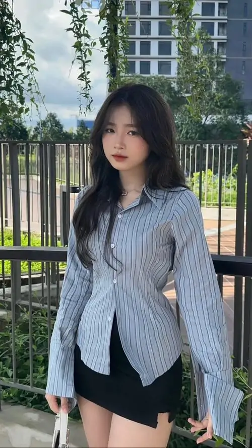 5 Khoảnh khắc thiếu nữ diện blazer xám với quần ngắn tối màu trước hàng rào thành phố, ánh mắt thẳng và dáng đứng gọn tạo vẻ thanh thoát, ảnh nữ xinh trong váy biến tấu này trông vừa ngầu vừa sang