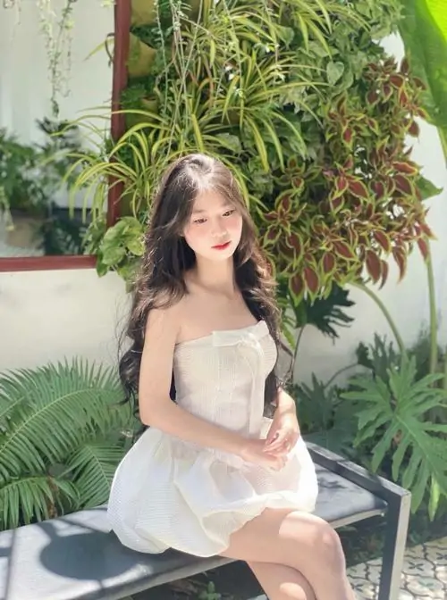 18 Bên cụm lá lớn bóng hồng diện váy trắng ngắn hai dây cho cảm giác mát mắt mềm mại và rất hợp khung cảnh xanh