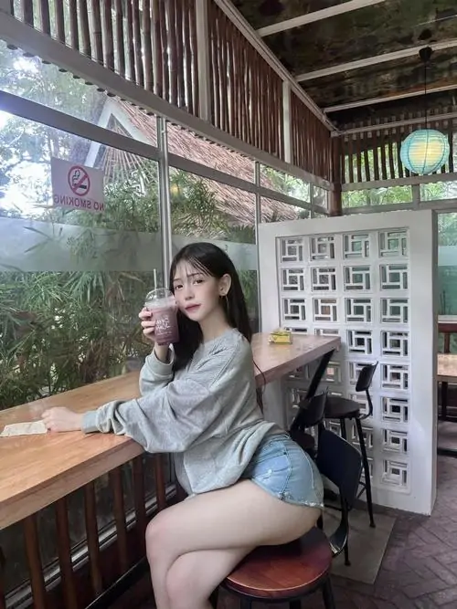 7 Ngồi bên bàn gỗ mỹ nhân mặc váy ngắn màu ghi ôm gọn cơ thể tạo vẻ gọn gàng hiện đại và khá cuốn hút