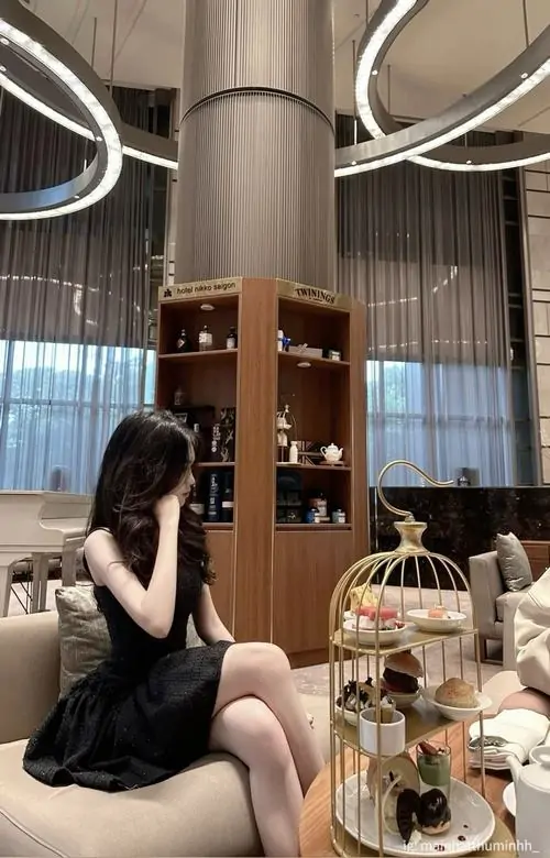 9 Vẻ hấp dẫn hiện lên rõ khi cô nàng ngồi quầy trà với váy trễ vai đen và túi xách mini nhỏ xinh