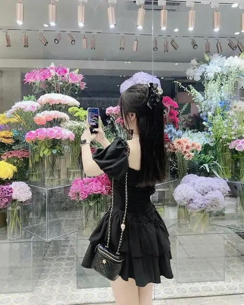 10 Khung hình quyến rũ ghi lại cô gái quay lưng giữa vườn hoa với váy chữ A đen bay nhẹ theo bước chân