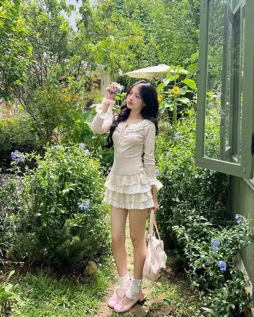 2 Ảnh gái xinh tạo dáng bên quán cà phê trong váy chữ A xếp nếp và áo sơ mi trắng mang chất thời trang học đường