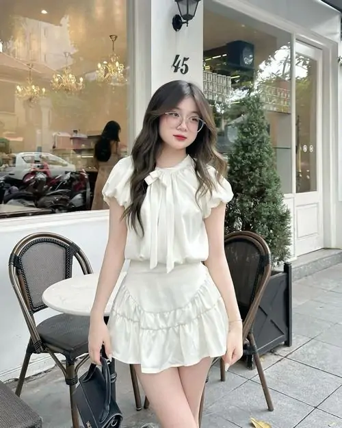 26 Ảnh cô gái mặc váy học đường xếp ly phối giày lười và tất cao cổ giữa lối đi dài mang nét tiểu thư rất duyên