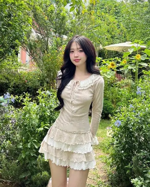 4 Ảnh gái xinh ngồi trên ghế đá với váy xếp ly ngắn màu hồng nhạt và áo len mỏng tạo vibe dạo phố ngọt mắt