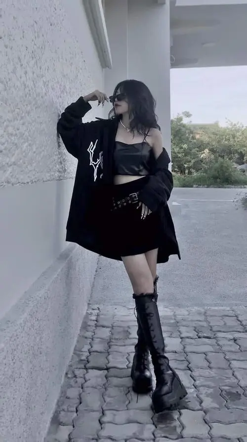 11 Thiếu nữ dễ thương đứng ngoài trời với áo khoác đen váy ngắn và đôi boots cao làm bật vẻ mạnh mẽ đầy tự tin