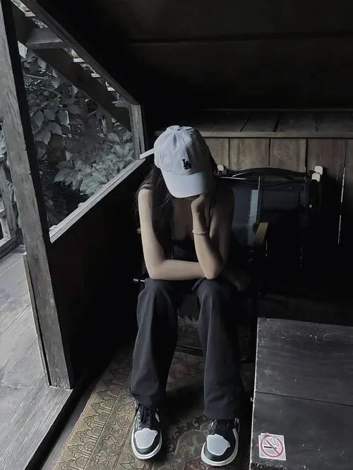 23 Gái đẹp ngồi thu mình ở góc tối với mũ trắng áo đen và quần rộng gợi chất bụi bặm rất đời thường
