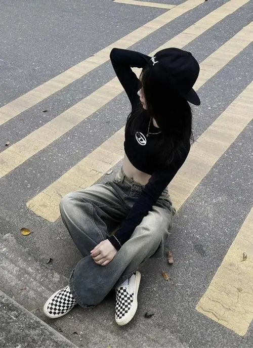 2 Gái đẹp ngồi giữa vạch qua đường trong hoodie đen mũ trùm kín tạo cảm giác bất cần rất đúng chất girl ngầu