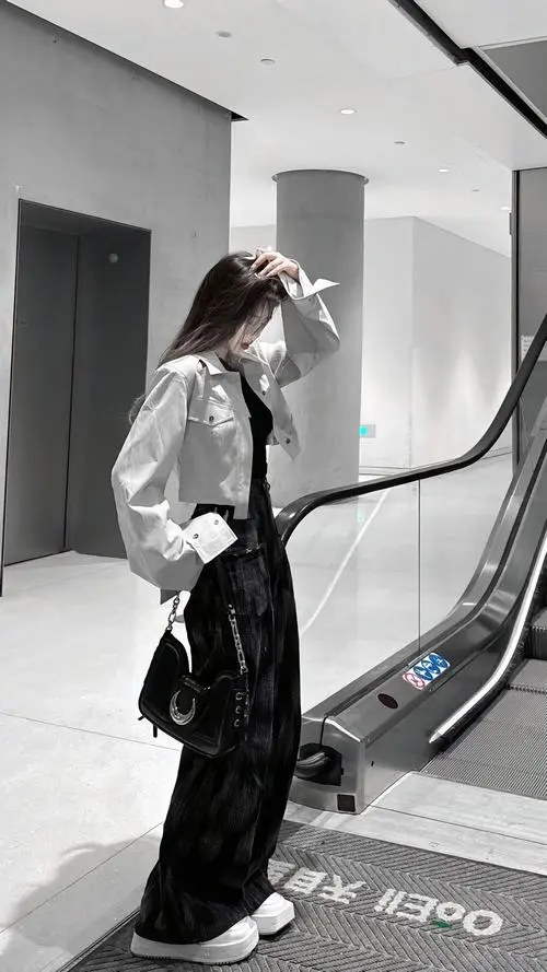 8 Ảnh gái xinh bước gần thang cuốn trong áo khoác ánh bạc quần suông rộng và mái tóc dài che nửa gương mặt