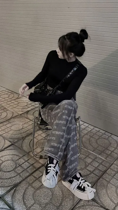 2 Girl phố che mặt ngồi co chân trên vỉa lát đá búi tóc cao cúi đầu tạo cảm giác lạnh lùng và xa cách