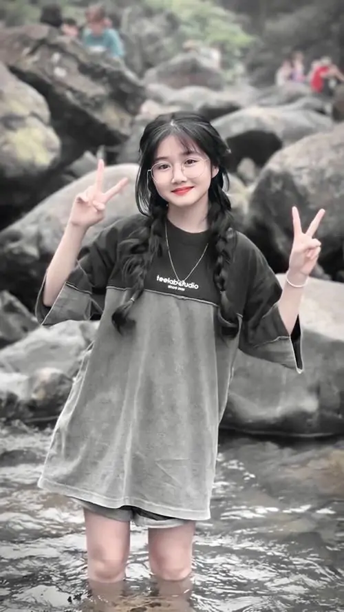 15 Bức hình gái đẹp ghi lại cô nàng mặc váy xám đứng giữa dòng nước nông bên ghềnh đá, tay giơ dấu vui vẻ và nụ cười tươi, vẻ đẹp bí ẩn được cân bằng bằng khung cảnh thiên nhiên mộc mạc, trong lành