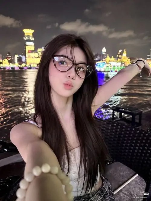 29 Ảnh gái xinh ghi lại cô gái mặc váy tối và kính tròn giữa khung cảnh thành phố về đêm, một tay giơ cao đầy hứng khởi, bờ vai mảnh cùng nụ cười nhẹ làm bức hình thêm tươi tắn và rất cuốn