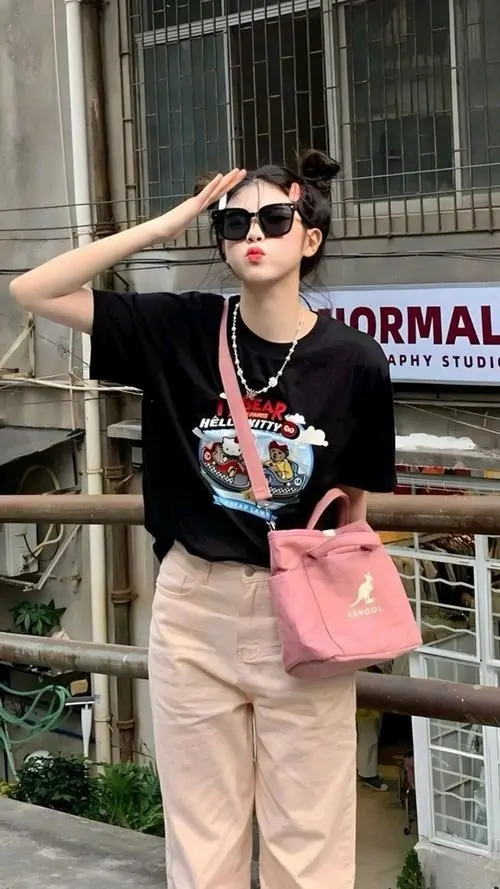 5 Khoảnh khắc cô nàng mặc áo đen in hình phối quần sáng màu và túi hồng đứng cạnh lan can, cặp kính đen cùng tư thế đưa tay lên trán khiến ảnh gái xinh ngầu đeo kính toát ra thần thái trẻ trung, tinh nghịch