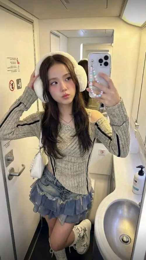 16 Cô gái tạo dáng trước gương trong lối đi hẹp, mặc váy ngắn với áo khoác ngoài, chân hơi chùng xuống tự nhiên, khiến ảnh gái xinh nhất thế giới có nét trẻ trung, ngầu nhẹ và hợp kiểu chụp dạo chơi buổi tối