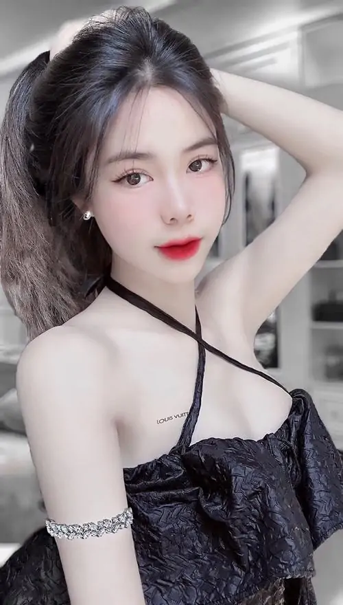 18 Cô gái diện váy hai dây đen, tay vòng lên đầu và nghiêng mặt sát máy ảnh, khung cận nửa người giúp ảnh gái đẹp đỉnh cao nổi rõ xương mặt thanh tú, vừa mềm mại vừa có nét cuốn khó rời mắt