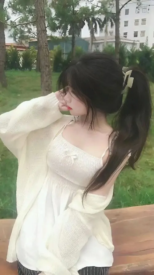 33 Cô gái mặc váy trắng rộng tay, quay đầu nhìn xuống giữa nền cỏ cây xanh mát, khung hình tạo cho ảnh gái xinh đẹp nhất thế giới vẻ dịu êm, nhẹ tênh và hợp những ngày có gió lùa qua tóc