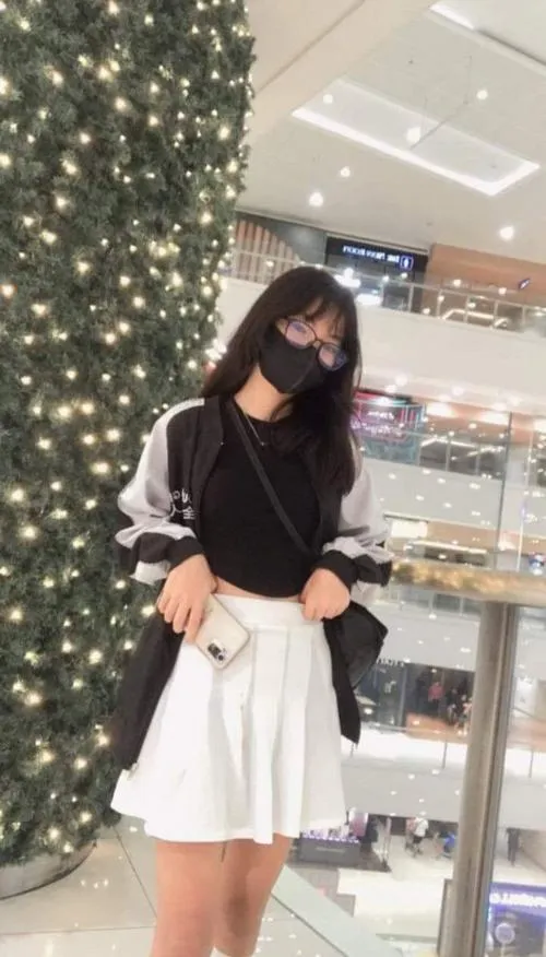 21 Cô gái mặc váy trắng đeo khẩu trang đứng trong trung tâm tạo cảm giác thanh lịch và hút mắt