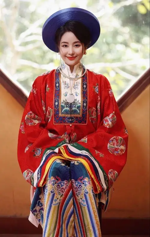 16 Nữ cosplayer Việt Nam mặc cổ phục đỏ xanh đậm đội mũ tròn truyền thống đứng giữa sân gỗ mang vẻ đẹp trang trọng