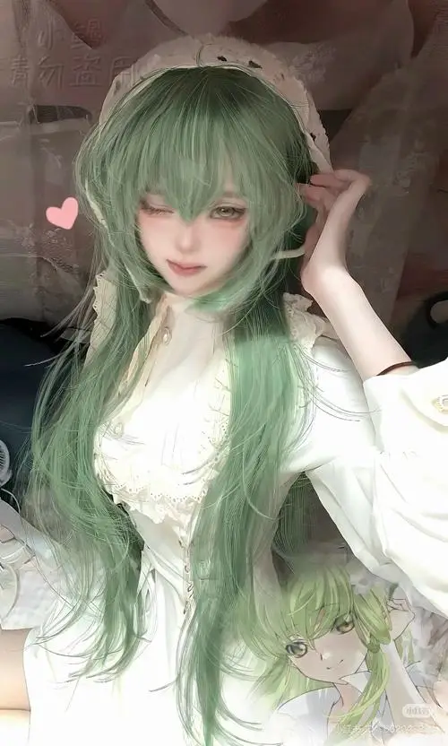 25 Nữ cosplayer Việt Nam mang tóc xanh lá dài dáng ngồi nghiêng nhẹ trong phòng tối làm ánh mắt thêm sâu và mềm