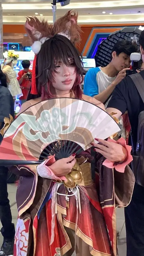 3 Ảnh hot girl cosplay với quạt xếp trên tay trang phục cổ phong đỏ tím và ánh nhìn mềm tạo hình rất hút mắt giữa đám đông