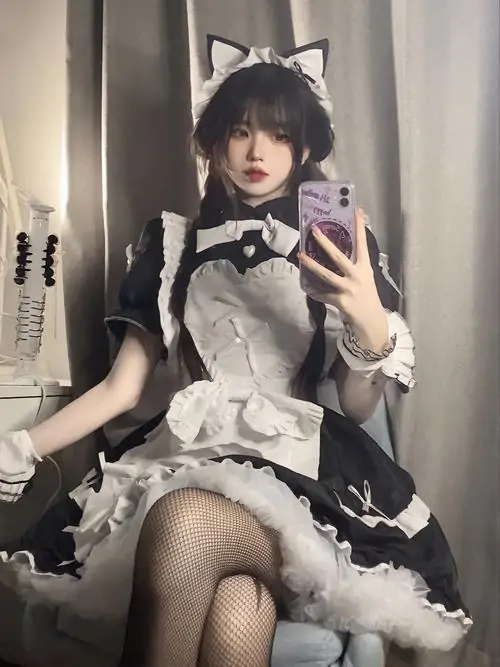 27 Thiếu nữ phục vụ diện váy xòe đen tạo dáng chuyên nghiệp trước gương mang lại vẻ đẹp tự tin và đầy cuốn hút.