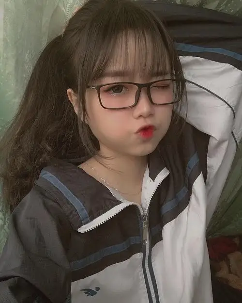 42 Cô gái ngồi bên cửa sổ với bàn tay đặt hờ lên tóc và mắt kiếng thanh mảnh tạo nét đẹp kín đáo nhưng rất hút mắt