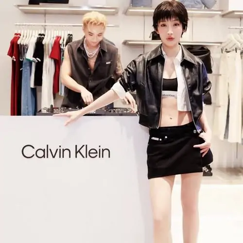 16 Khoảnh khắc tại sự kiện thời trang ghi lại Juky San đứng cạnh quầy Calvin Klein với áo da ngắn và chân váy đen, tạo cảm giác hiện đại, sắc nét nhưng vẫn giữ chất nữ tính, rất hợp kiểu ảnh nghệ sĩ đầy thu hút