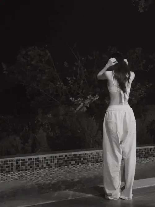 17 Bức ảnh trắng đen ghi lại Juky San trong chuyển động uyển chuyển giữa không gian tối, tà váy trắng bung nhẹ theo từng nhịp tay, tạo nên cảm giác vừa mơ màng vừa điện ảnh, như một lát cắt đầy cảm xúc của bộ ảnh