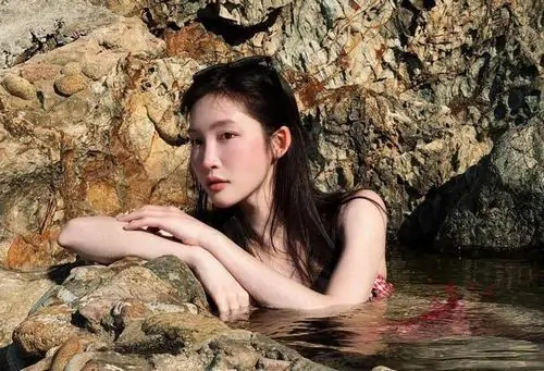 7 Khung ảnh cận của bộ ảnh Juky San bikini tập trung vào gương mặt nghiêng tựa lên phiến đá, làn nước ôm quanh bờ vai khiến cảm xúc trở nên mềm hơn, vừa mong manh vừa gợi cảm, đúng kiểu nàng thơ mùa hè