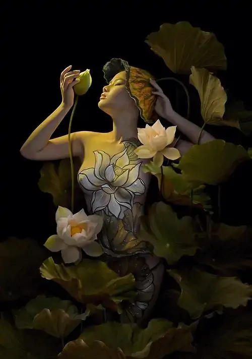 23 Hình gái ẩn dưới lớp lá sen vàng xanh trong nền đen sâu, cơ thể chỉ hé những mảng da có chủ ý, ảnh khỏa thân thẩm mỹ dùng ngôn ngữ thị giác giàu chất tạo hình để tăng vẻ bí ẩn và lôi cuốn