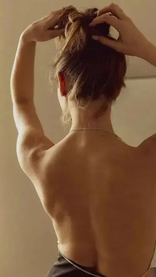 29 Lưng trần hiện trong nền vàng hổ phách, hai cánh tay vòng qua đầu làm xương bả vai nổi nhẹ, bức ảnh nuy nghệ thuật tối giản đạo cụ để giữ mắt nhìn ở đường cong cơ thể và nhịp thở rất thật