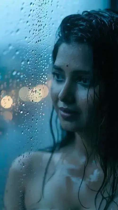 6 Nửa gương mặt và bờ ngực hiện sau lớp kính đẫm nước, sắc xanh lạnh phủ lên làn da khiến khung hình có chiều sâu cảm xúc, kiểu chụp tối giản này giữ nhịp nhìn chậm và rất giàu chất mơ
