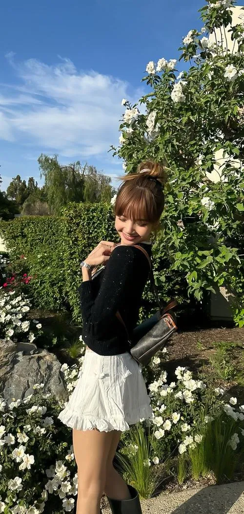 1 Lalice đứng giữa vườn xanh với áo đen váy trắng tôn đôi chân dài và vẻ nữ tính trong trẻo