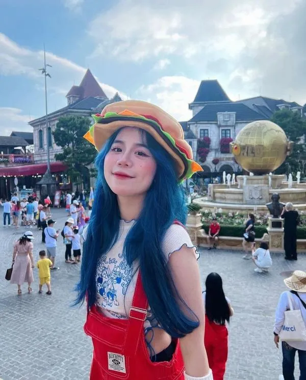 Bắt gặp Simmy ngoài trời đội mũ xinh bối cảnh đông vui nắng lên tóc nhẹ hot girl rạng rỡ