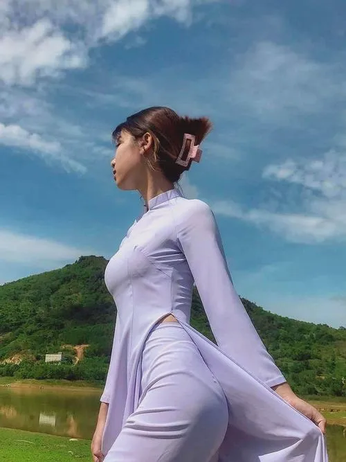 30 Nữ sinh trong áo dài trắng ngồi nghiêng giữa nền trời xanh vóc dáng thanh mảnh làm bức ảnh trở nên thoáng và rất thơ