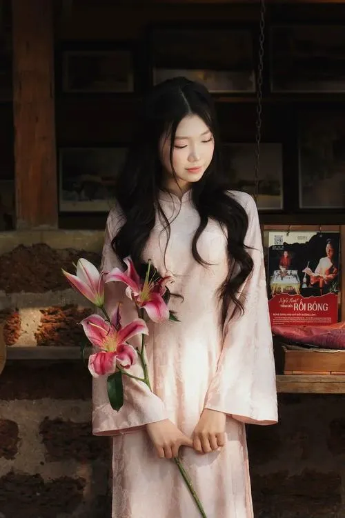 28 Cô gái váy sáng đứng trong không gian tối ôm bó hoa nhỏ làm khung hình thêm thơ và có chút lặng lẽ