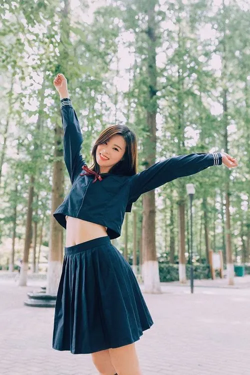 6 Cô gái váy xanh xoay người giữa hàng cây cao mang vẻ hồn nhiên và trẻ trung như vừa bước ra từ một buổi tan trường