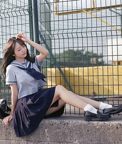 11 Thiếu nữ dễ thương ngồi bên lưới sân bóng với váy tối màu và tất cao cổ gợi vibe thanh xuân