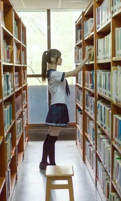 15 Ảnh gái xinh giữa kệ sách cao mặc váy tối và áo sáng dáng đứng nhỏ nhắn rất hợp lớp học