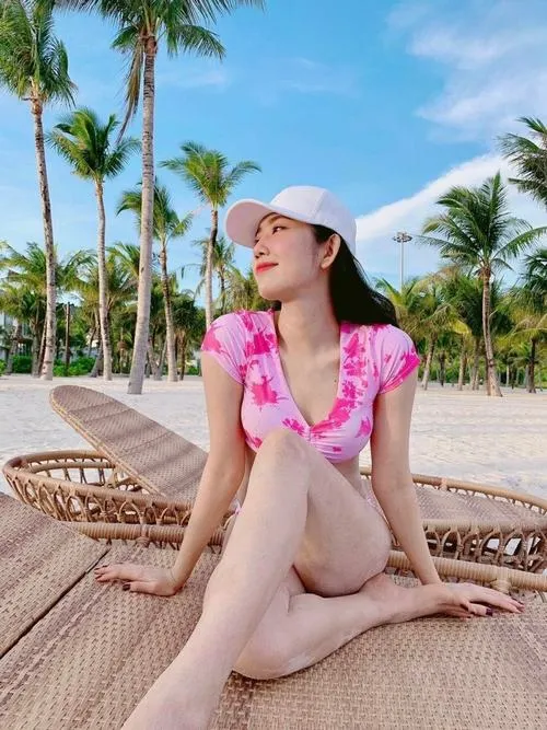 5 Ảnh đi biển của Thúy Ngân trên ghế tắm nắng, dáng đứng chữ S tôn eo, tóc bay nhẹ