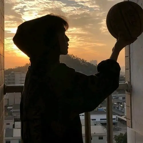 23 Hình trai xinh k12 ghi lại cậu bạn áo trắng đứng giữa ánh đèn đêm hơi mờ, bàn tay giữ điện thoại và gương mặt nghiêng làm tổng thể có chút chờ đợi, hợp kiểu ảnh học đường pha chất đời thường đẹp mắt