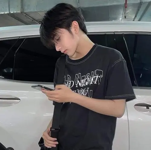 28 Cậu bạn k12 mặc áo tối chụp selfie sát mặt với nụ cười mím nhẹ, phần tóc ôm trán giúp gương mặt bầu bĩnh hiện rõ hơn, tổng thể hợp dùng trên Instagram theo kiểu avatar học đường trẻ trung và sạch