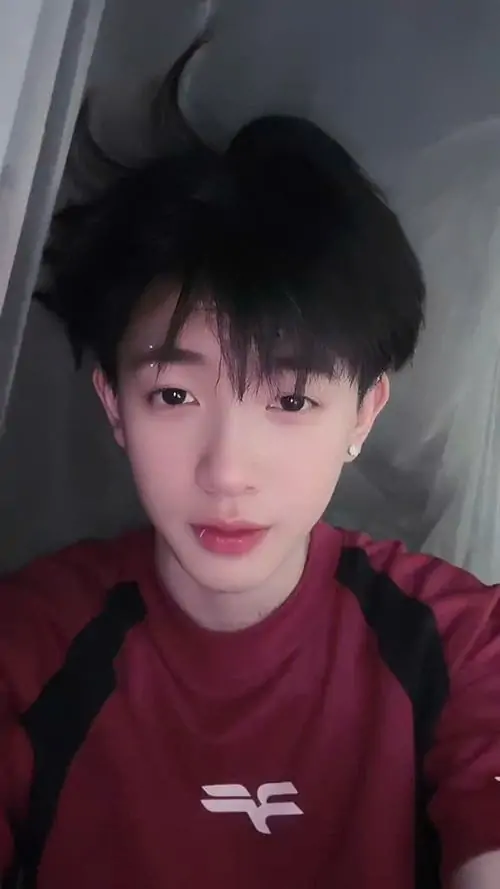 6 Cậu bé 2k12 mặc áo đỏ đứng trong góc nhà, tóc rối nhẹ và gương mặt nhỏ tạo nét non rõ rệt khá rõ, ảnh selfie đơn giản nhưng vẫn đẹp mắt, đúng kiểu phong cách Gen Alpha hay chia sẻ trên Instagram