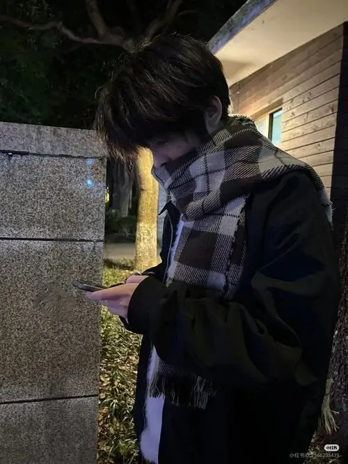 18 Chàng trai trong áo khoác caro tối đứng dưới đèn, đưa điện thoại lên sát mặt như tránh ống kính, tóc rũ xuống thêm một lớp che phủ, nên khung hình trông sexy và có chiều sâu của mood đêm